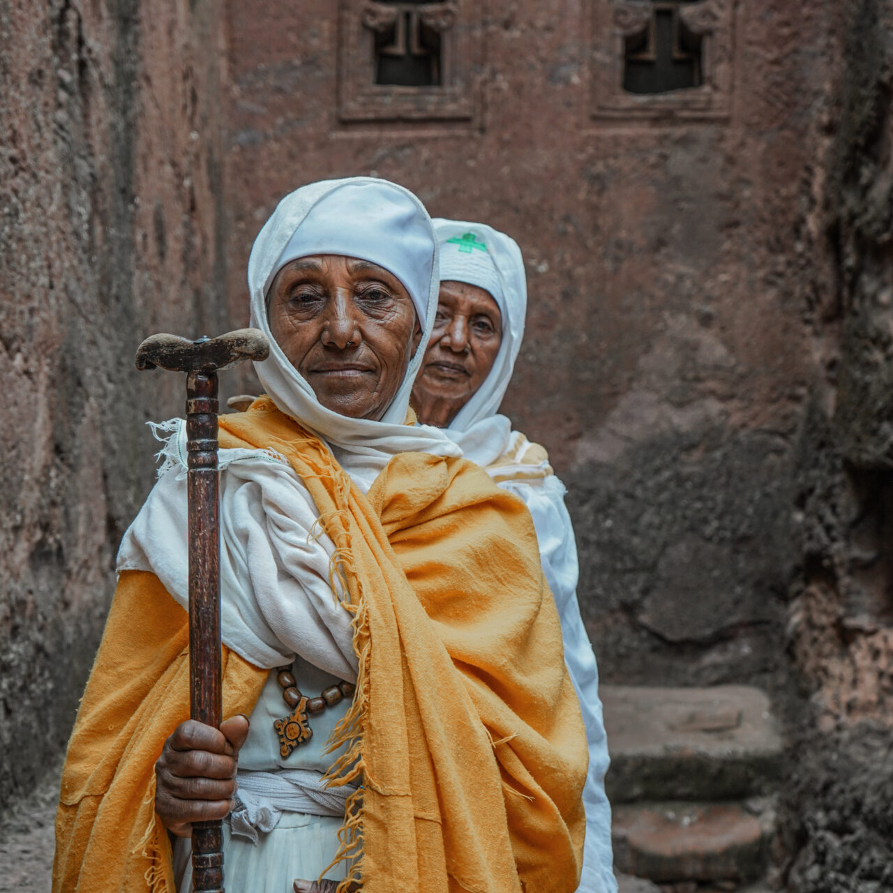 Nuns infront of Bet Michael in Lalibela https://untoldethiopiatours.com/wp-content/uploads/2018/09/Nuns-infront-of-Bet-Michael-in-Lalibela-1280x1280.jpg